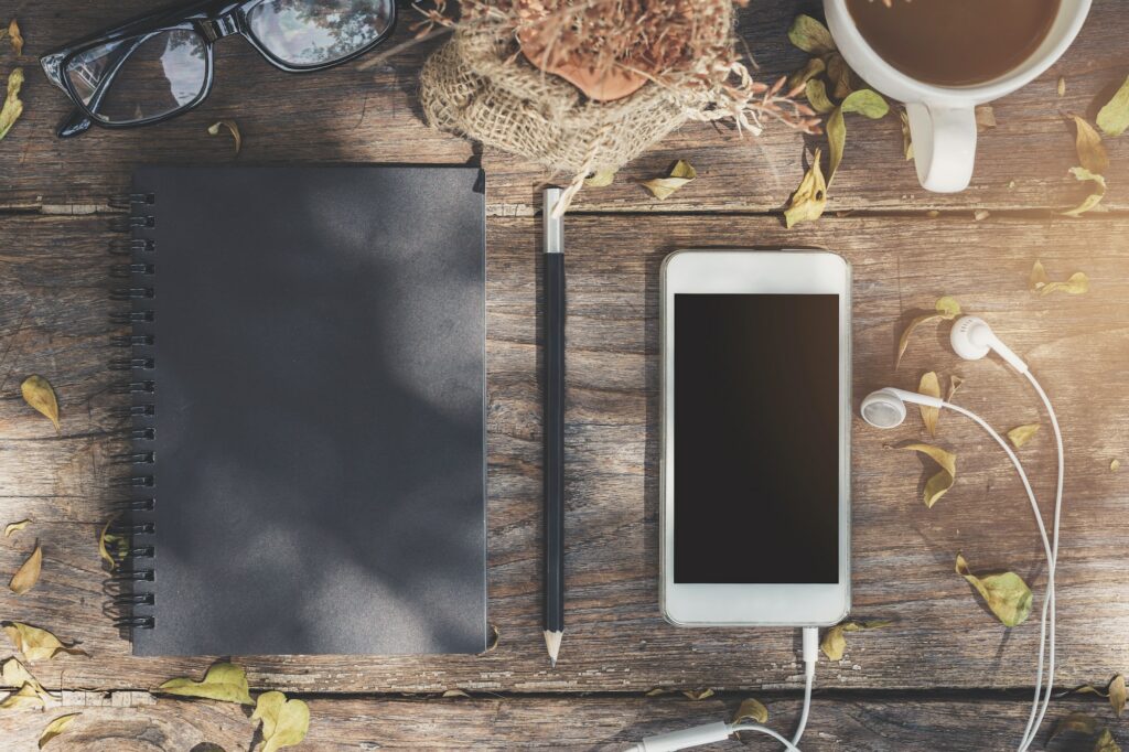 Notebook with cup of coffee and cellphone