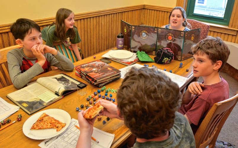 Stefani Laflamme, top right, who works as a dungeon master for Dungeons and Dragons at Lilly Library in Florence, talks to Ivan Harder, 10, from left, Astra Stathis-Lowe, 9, Stuart Hawley, 12, and Sam Robbins, 11, during a game, Wednesday, June 19, 2019.