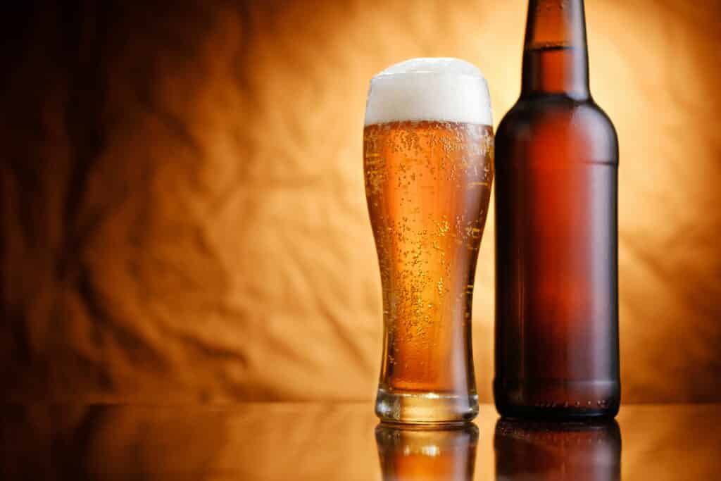 Ice cold pint of beer in a bottle and glass