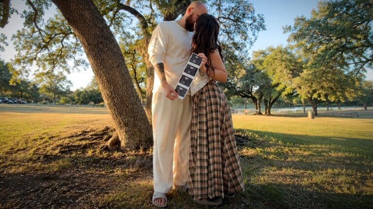 Tectone and his partner holding ultrasound photos together in a park
