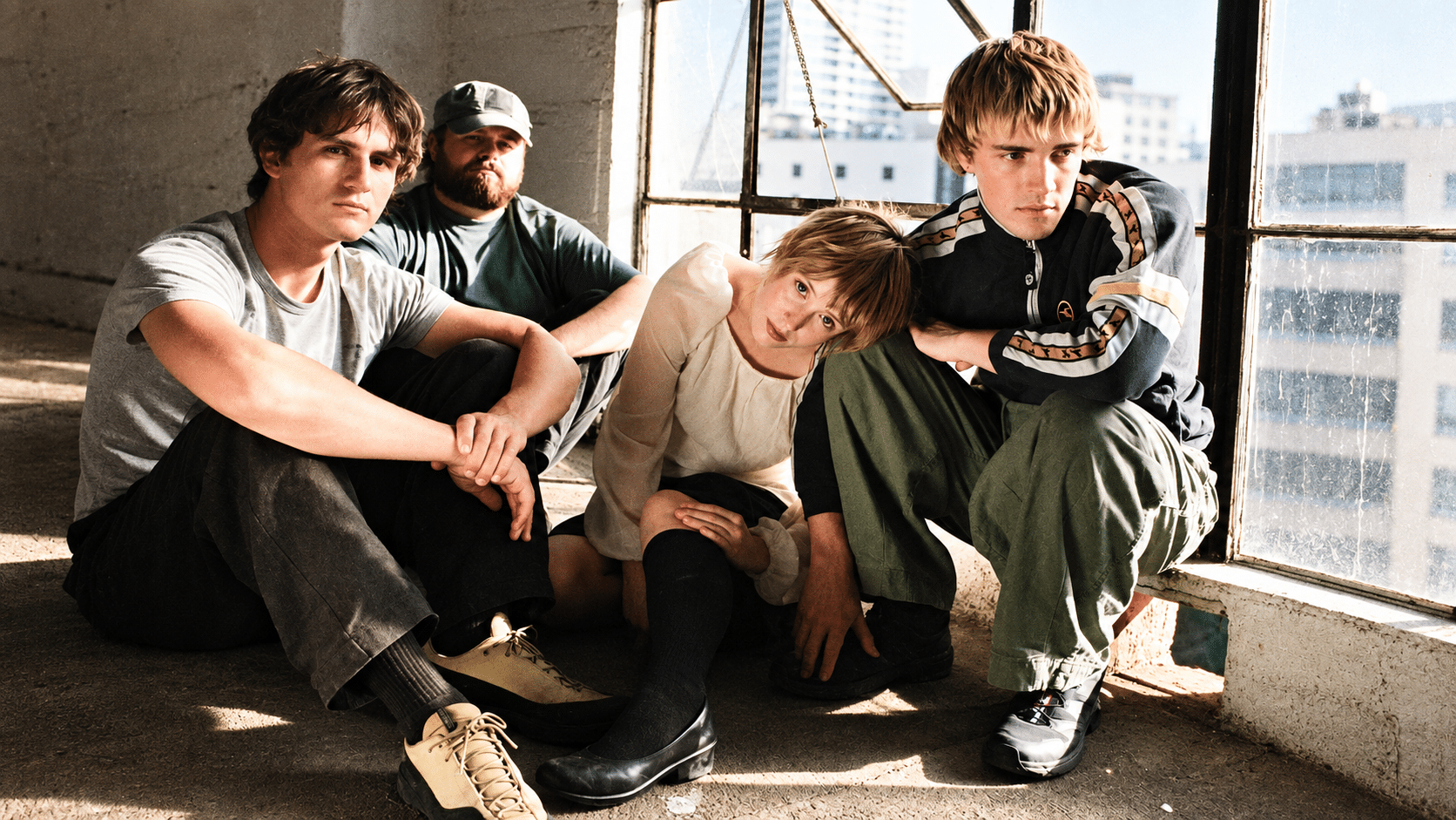 The four members of Swapmeet sitting together beside a sunlit window