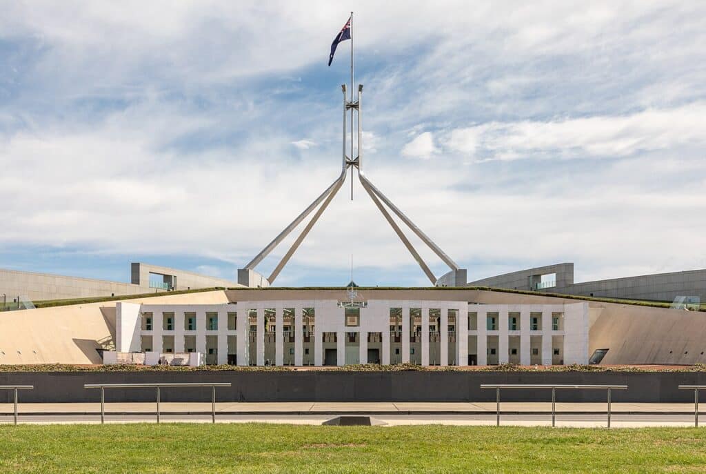 Australian Parliament House in Canberra beneath a cloudy sky