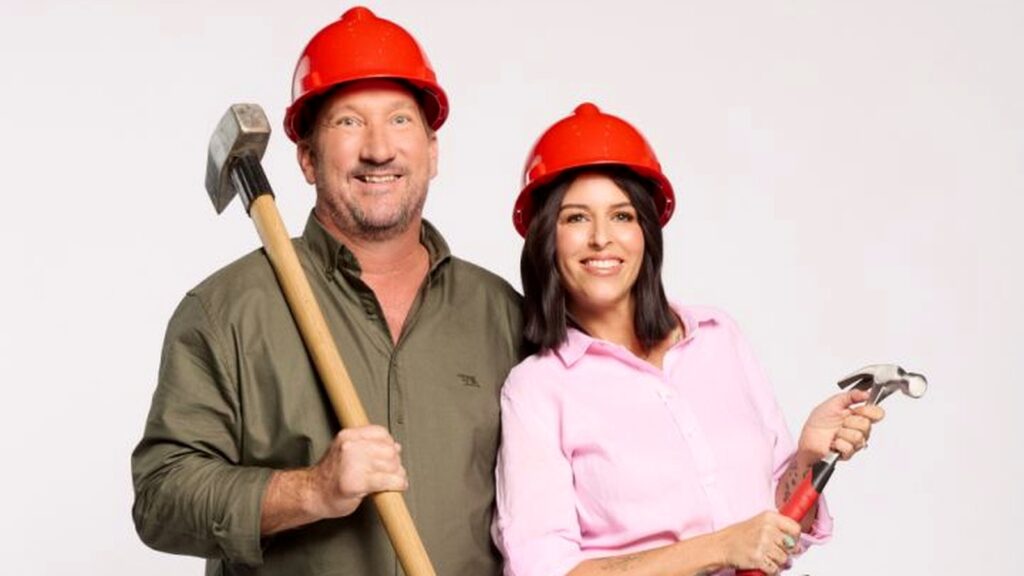 Adam and Jolene in red hard hats with renovation tools
