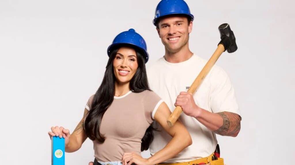 Chantel and Wyatt in blue hard hats with renovation tools