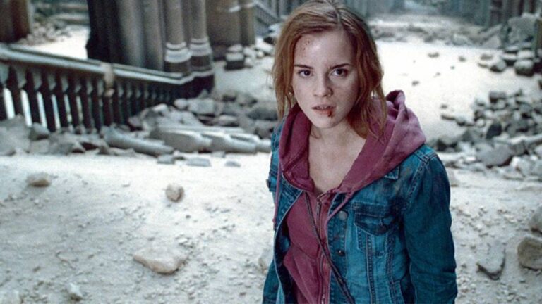 Emma Watson as Hermione Granger standing amid the ruins of Hogwarts in Harry Potter and the Deathly Hallows – Part 1