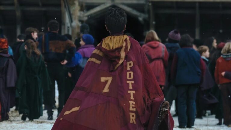 Dominic McLaughlin as Harry Potter in Gryffindor Quidditch robes on a snowy Hogwarts pitch