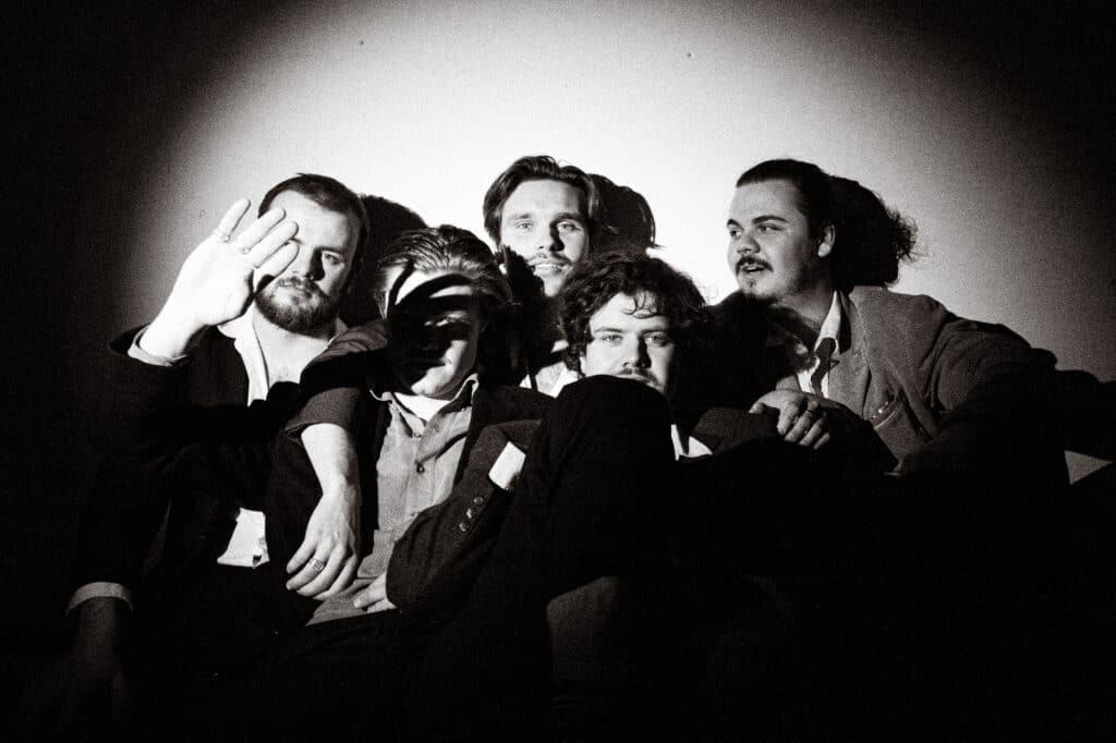 BOCCE gathered closely together in suits in a black-and-white publicity portrait