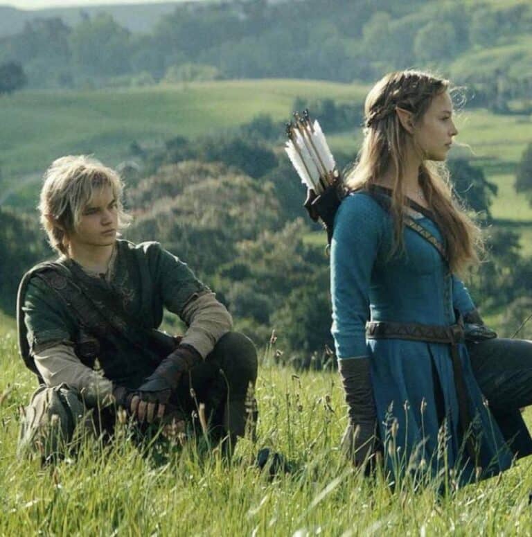 Benjamin Evan Ainsworth as Link beside Bo Bragason as Princess Zelda in a grassy Hyrule landscape
