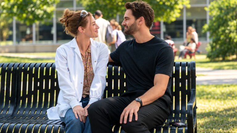 Olive and Adam exchange an affectionate look on a campus bench in The Love Hypothesis