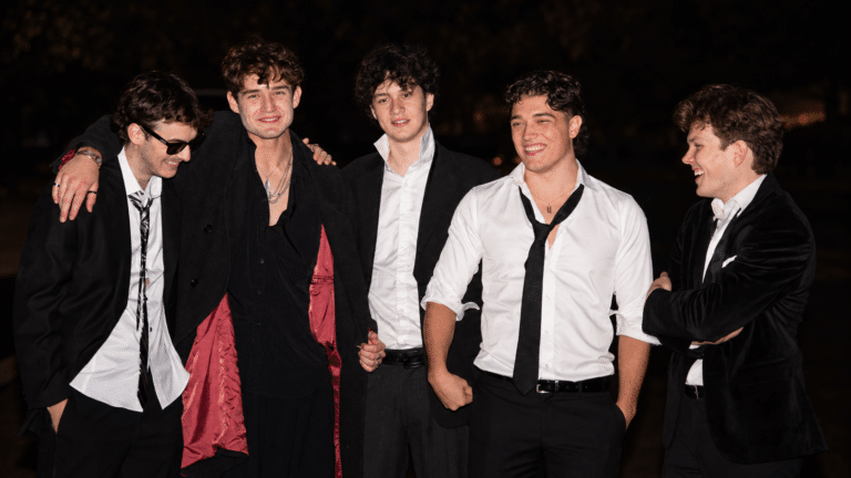 The five members of The Kickons standing arm in arm outside at night