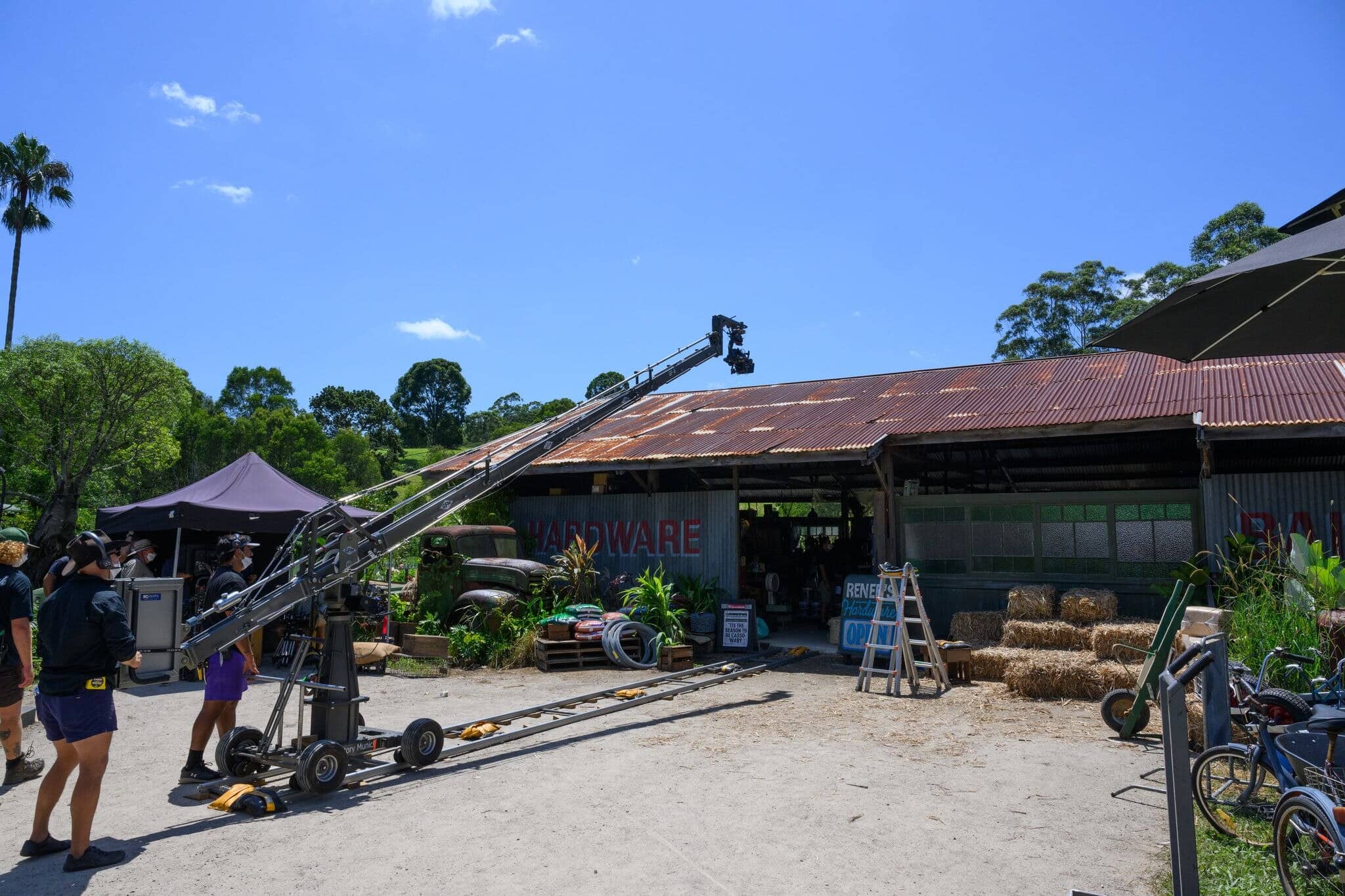 A camera crane and crew filming beside a rural Queensland building