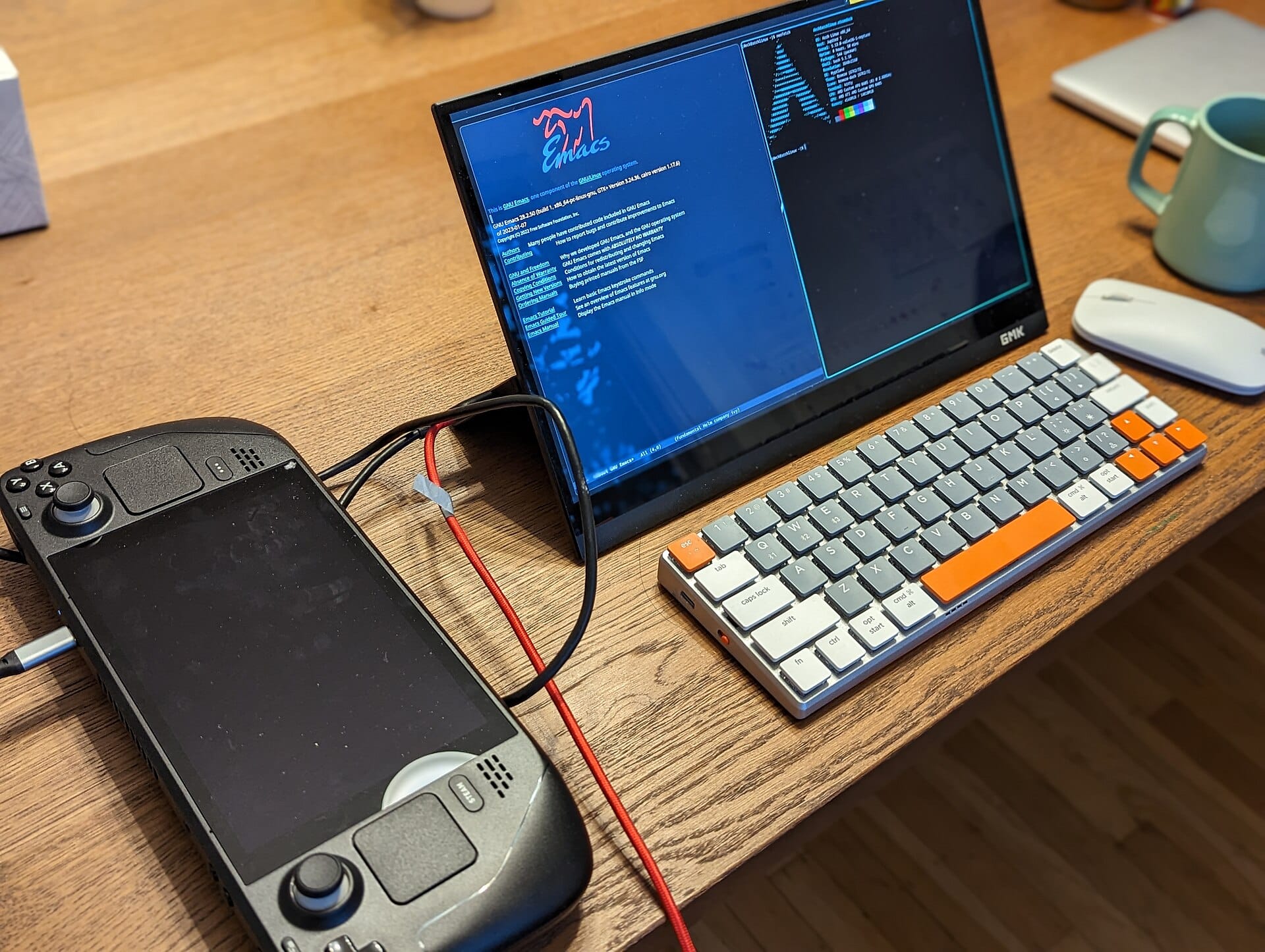 A Steam Deck connected to a portable monitor showing a Linux desktop.