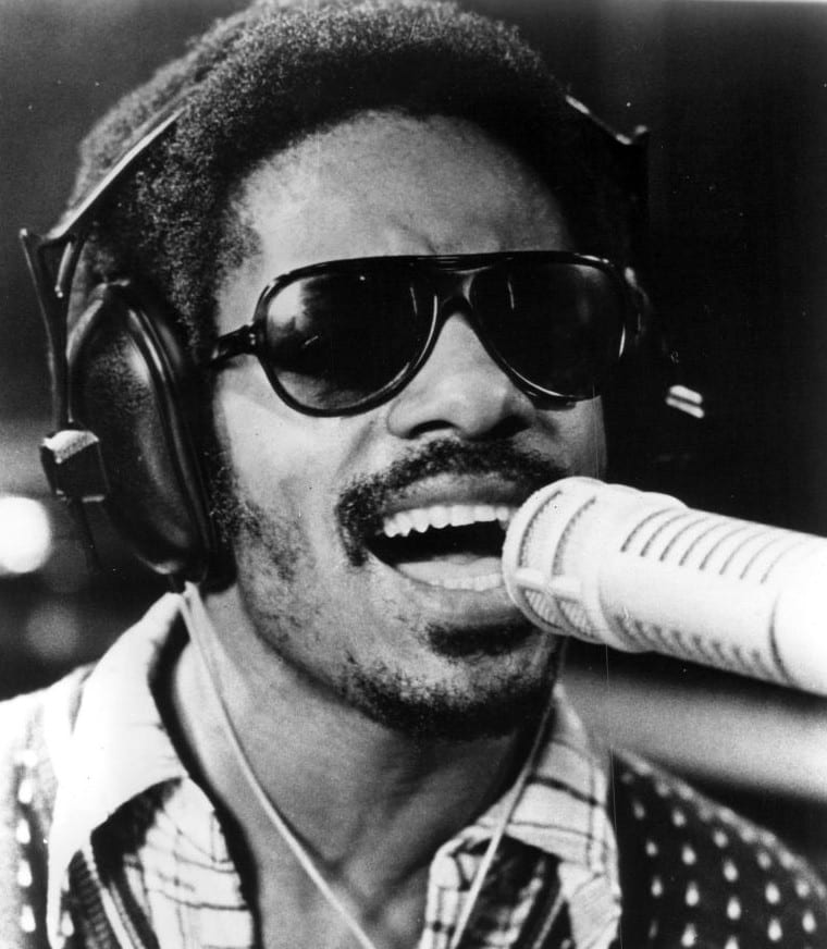 Stevie Wonder singing into a studio microphone in a 1973 Motown publicity photograph