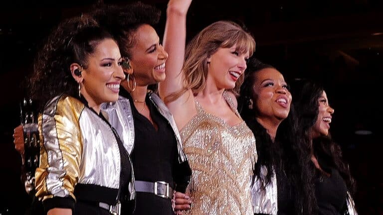 Taylor Swift smiling with dancers during the Eras Tour