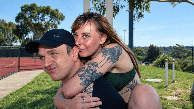 Sydney duo smallways. in an outdoor piggyback portrait beside a sports court