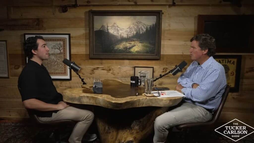 Tyler Oliveira speaking with Tucker Carlson in a podcast studio