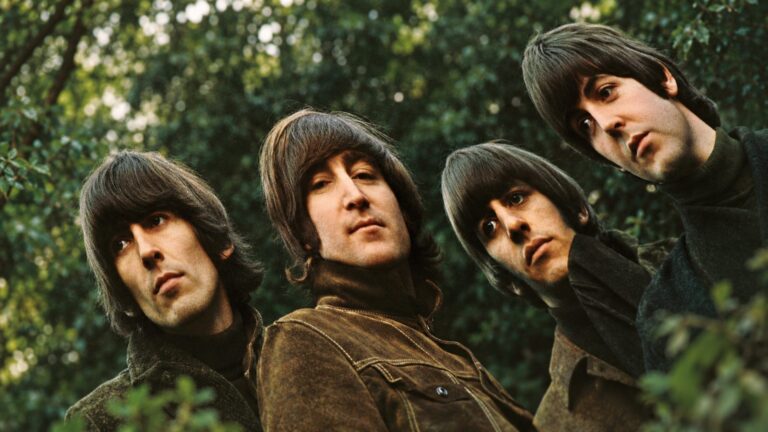 The Beatles photographed together in a green woodland setting