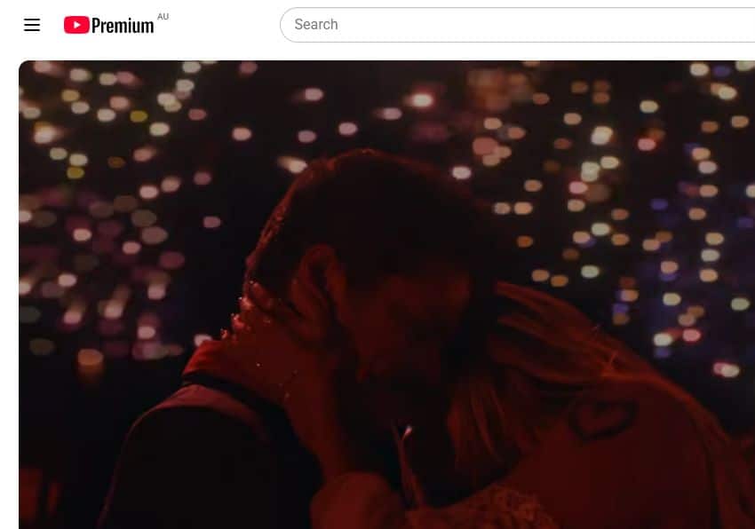 Bruno Mars and Karol G embracing beneath fireworks in the Dance With Me music video