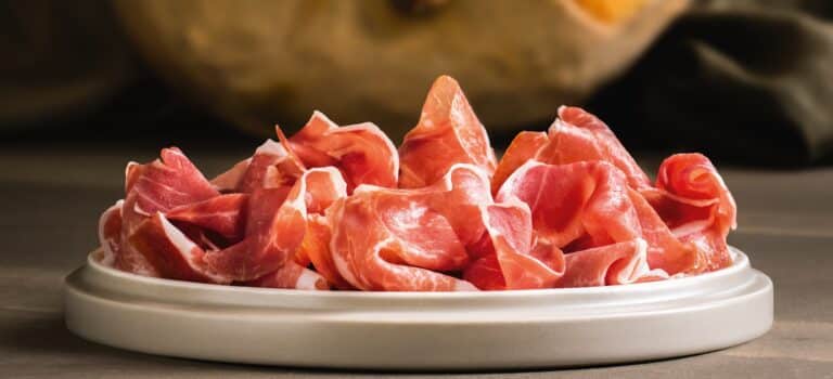 Slices of Prosciutto di Carpegna on a white plate