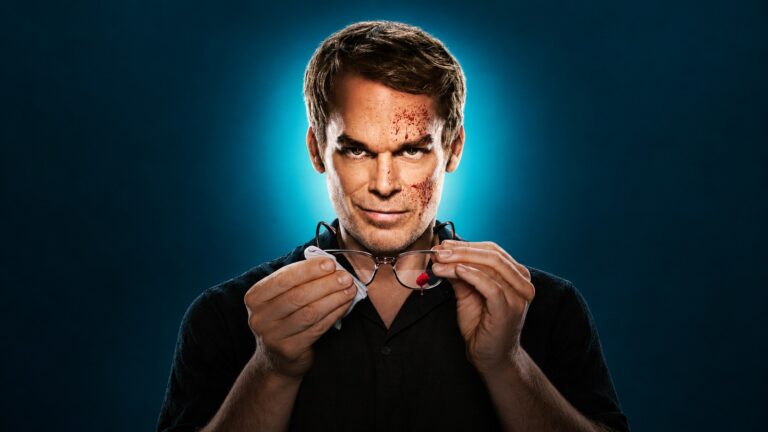 Michael C Hall as Dexter Morgan cleaning his glasses against a dark teal background