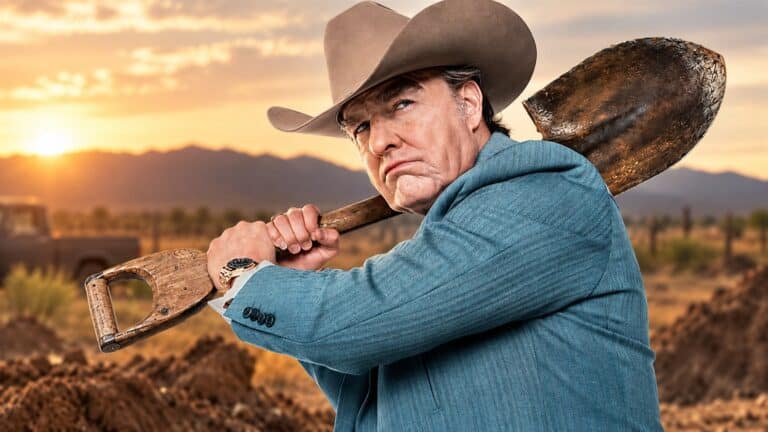 Tom Cruise as Digger Rockwell carrying a shovel at sunset
