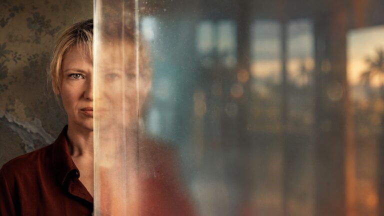 Anna Torv as Detective Tig Pollard seen through reflective glass in Dustfall