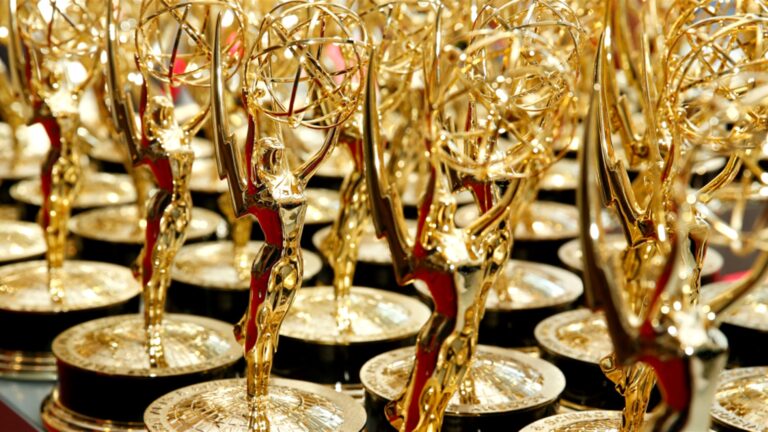 Rows of golden Emmy statuettes with one trophy sharply in focus