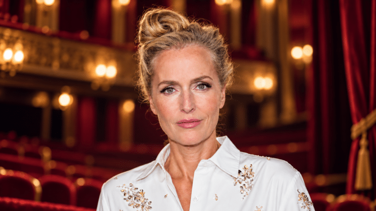 Gillian Anderson in a softly lit theatre auditorium