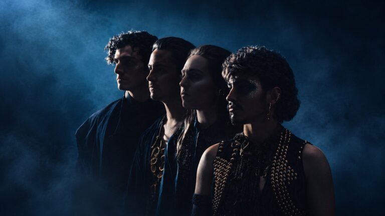 Greta Van Fleet band members in a moody blue studio portrait
