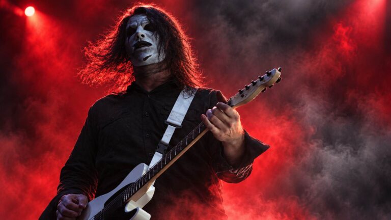 Slipknot guitarist Jim Root performing through red stage haze