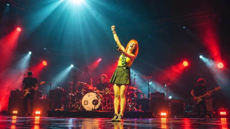 Hayley Williams performing under red and blue stage lights