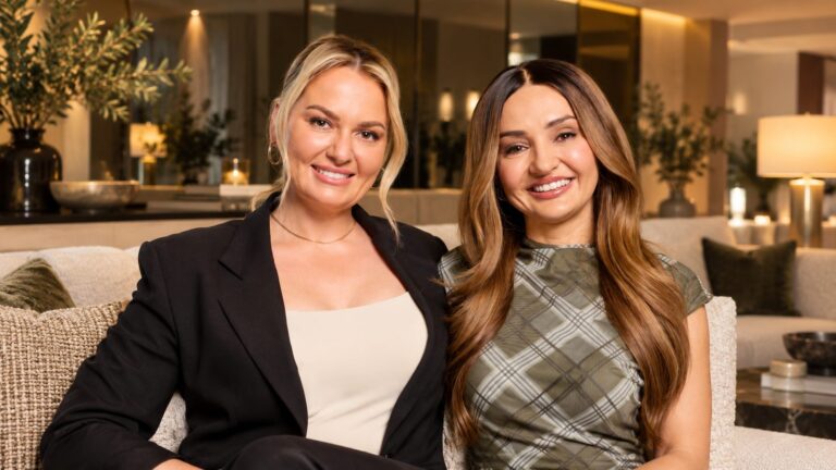 The Block contestants Courtney and Sev seated in a modern living room with a mirrored wall
