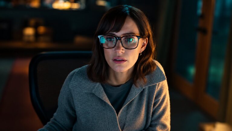 Jessica Chastain wearing glasses at a dark computer workstation in The Savant