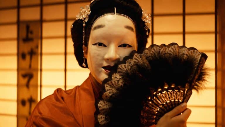 A Noh masked performer holding a fan in Trivium's Crown In The Grave video