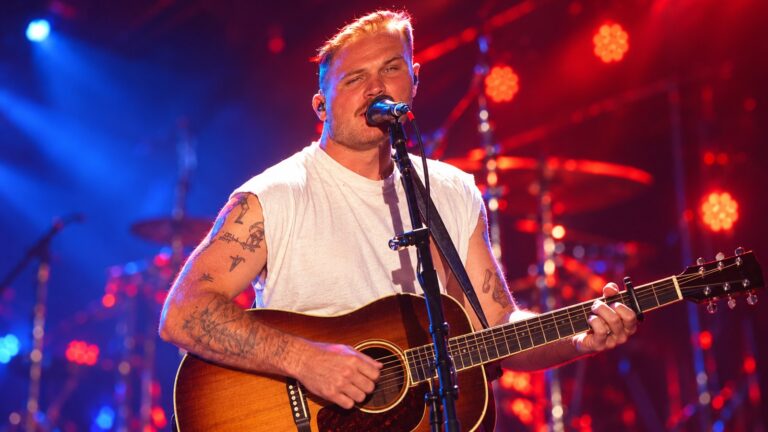 Zach Bryan performing live with acoustic guitar
